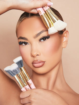 An image of a woman model wearing makeup holding the P.Louise Spoilt For Choice 5-Piece Makeup Brush Set against her face