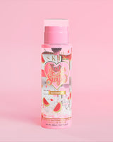 Eine Flasche P. Louise Just A Swipe Mizellenwasser mit Wassermelonenduft und Wassermelonendesign auf der Flasche vor einem rosa Hintergrund