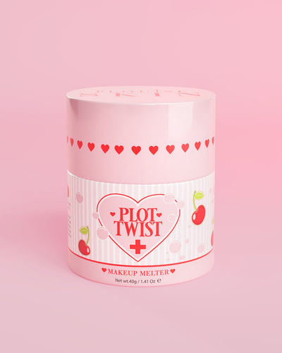 Ein rosa Behälter mit P.Louise Plot Twist Makeup Melting Cleansing Balm mit Herz- und Kirschmotiven auf dem Etikett vor einem rosa Hintergrund
