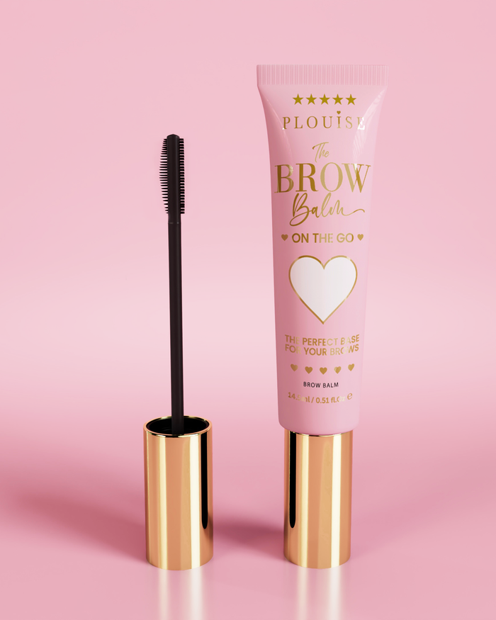 P.Louise Fluffy Soap Brow Balm Instant Fix Produkt in einer rosa Tube mit goldener Kappe, begleitet von einem schwarzen Augenbrauenpinsel, präsentiert vor einem rosa Hintergrund.