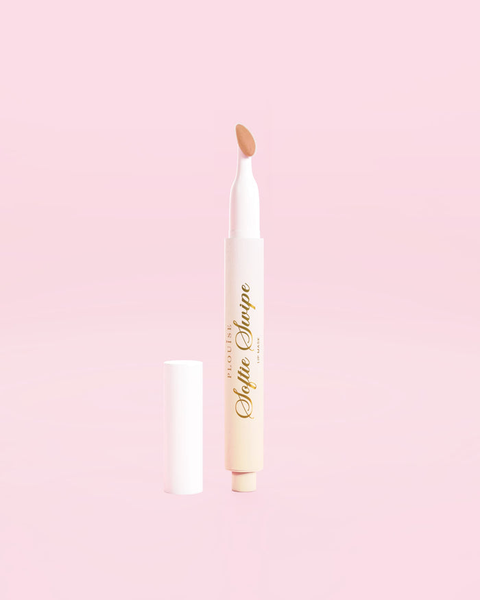 Ein Bild, das die P.Louise Softie Swipe Tinted Lip Mask im Farbton „Barely There“ vor einem rosa Hintergrund zeigt