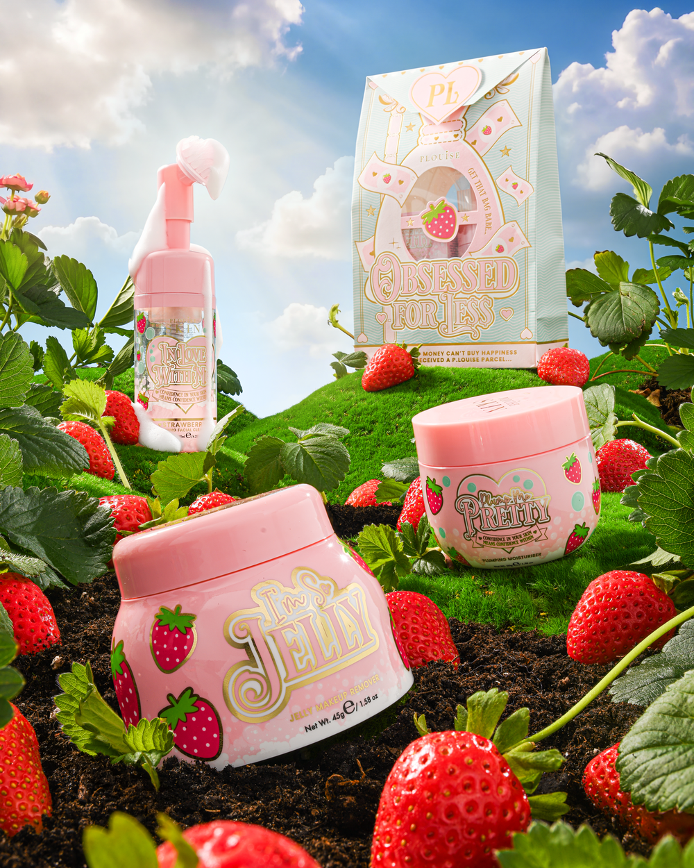 P.Louise Strawberry Obsessed For Less Double Cleanse & Moisturise Skincare Set auf einem grasbewachsenen Hügel, umgeben von Erdbeeren