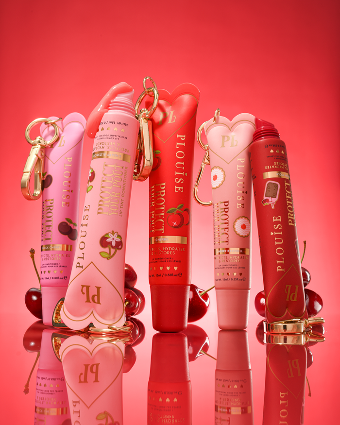 Set aus P.Louise-Tuben mit Kirschduft und getöntem Lippenpflegemittel zum Schutz Ihrer Lippen auf rotem Hintergrund