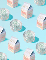 Clear containers of P.Louise Dose of Dreams Vitamin C Capsule Cream with blue capsule within them surrounded by  milk cartons
