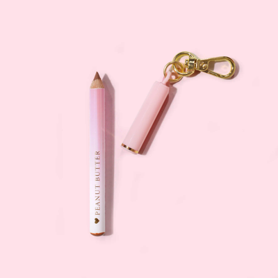 Rosa P.Louise Mini-Schlüsselanhänger-Lipliner mit „Peanut Butter“-Branding auf hellrosa Hintergrund