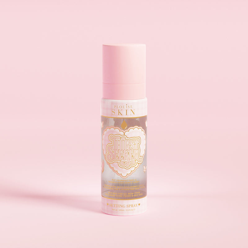 Eine rosa Sprühflasche mit der Aufschrift „P.Louise SKIN“ mit der Darstellung eines Herzens und einigen floralen Elementen, die ein feuchtigkeitsspendendes Fixierspray enthält.