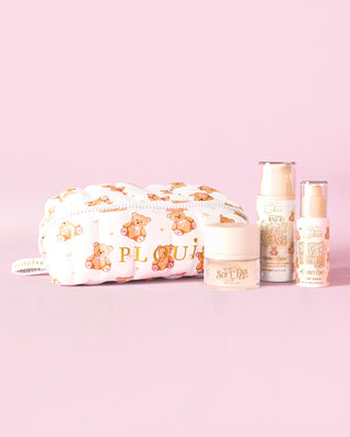 Ein Bild des P.Louise Softest Touch Skincare Starter Kit mit einer Make-up- und Hautpflegetasche mit großem Teddybär-Aufdruck und drei Hautpflegeprodukten vor einem rosa Hintergrund