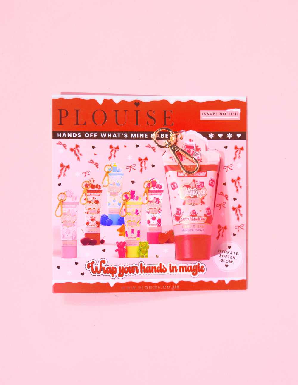P.Louise-Weihnachtsmagazin mit einem am Magazin befestigten Mini-Schlüsselanhänger mit frecher Cranberry-Handcreme und festlichem Design in Rot und Rosa