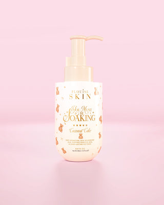 Flasche P.Louise You Must Be Einweichendes Badeöl in Kokosnusskuchen vor einem rosa Hintergrund
